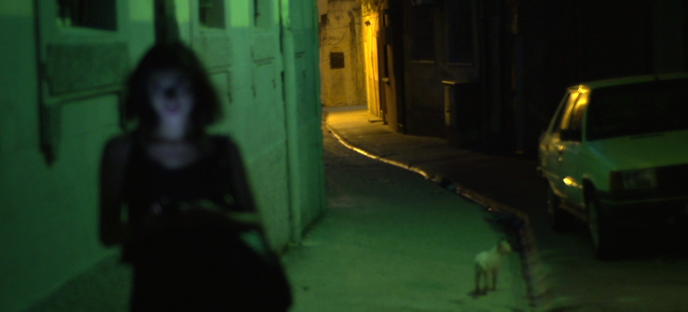 Une jeune femme marche dans les rues sombres d'une ville en Syrie