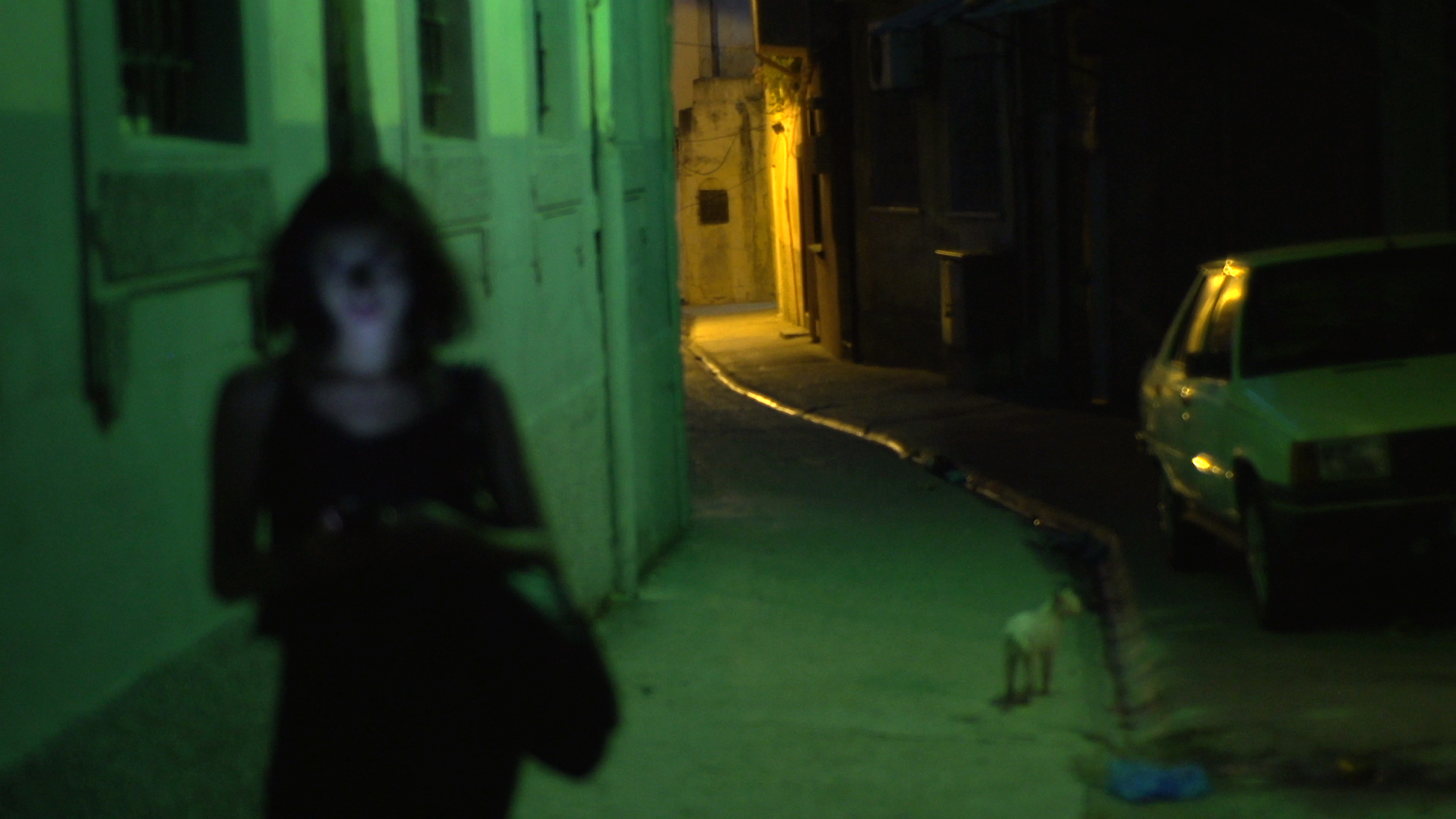 Une jeune femme marche dans les rues sombres d'une ville en Syrie