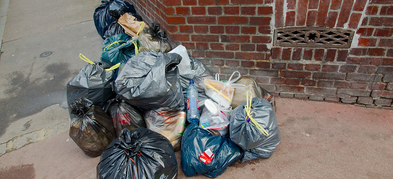 Des déchets et des sacs poubelle sont entassés.