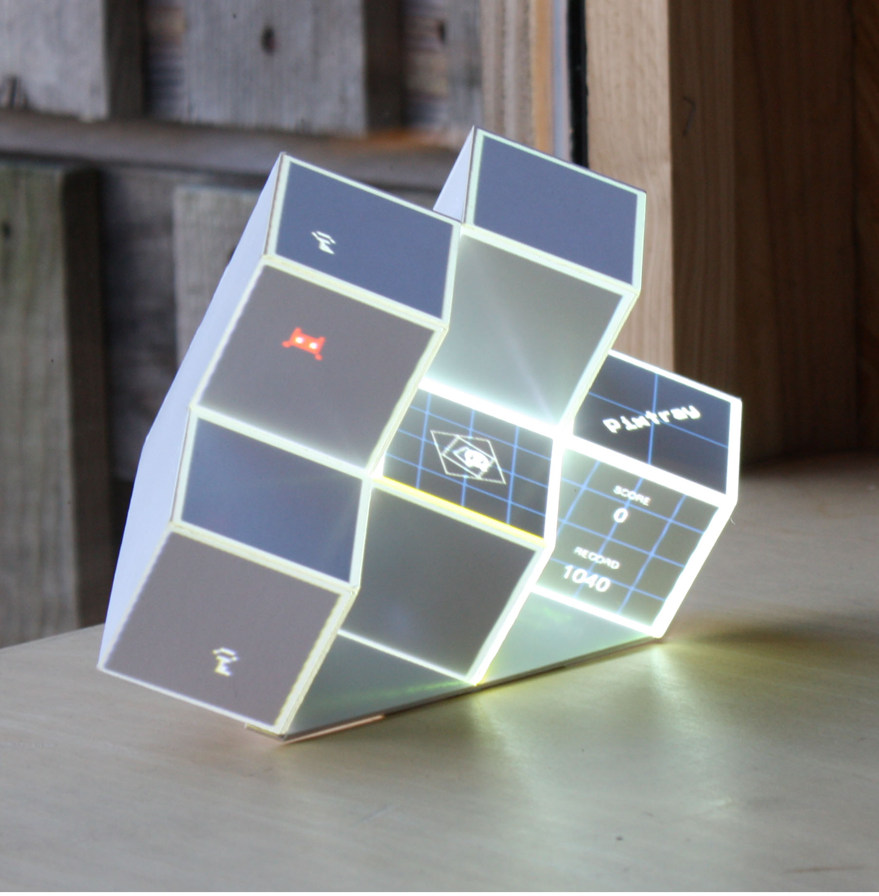 Le jeu Pixtray posé sur une table : un objet multicubique et lumineux.