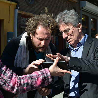 Deux personnes manipulent une tablette avec curiosité.
