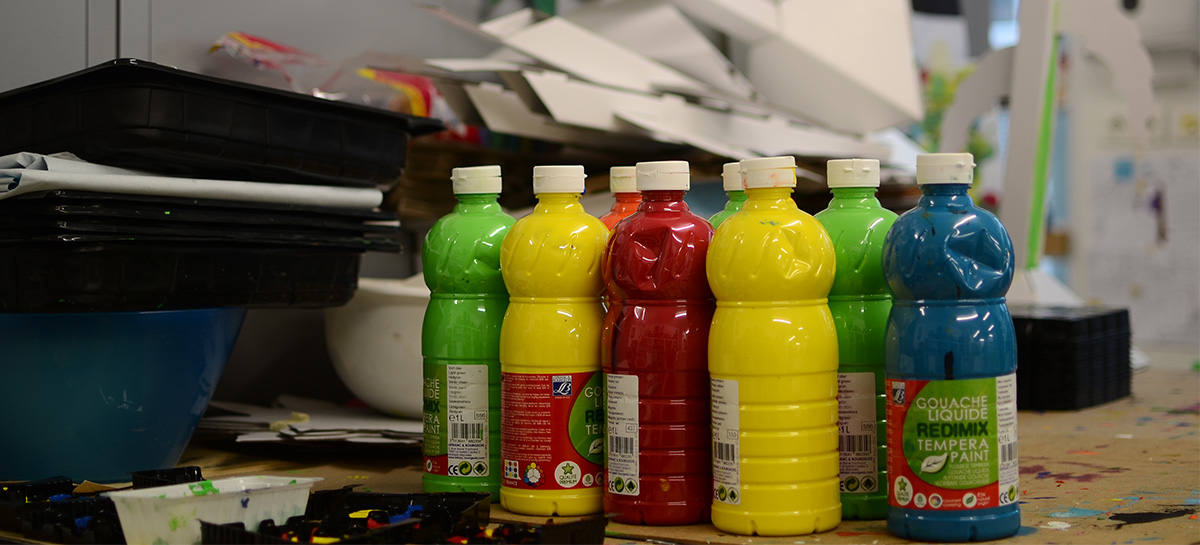 Des pots de peinture de couleur sont posés sur une table.