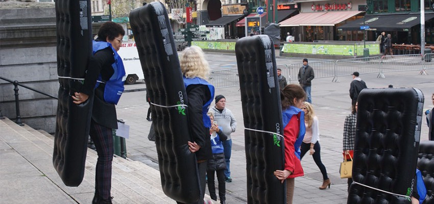 Les participants, munis de leur matelas pour le domino humain, se place en face de la Bourse