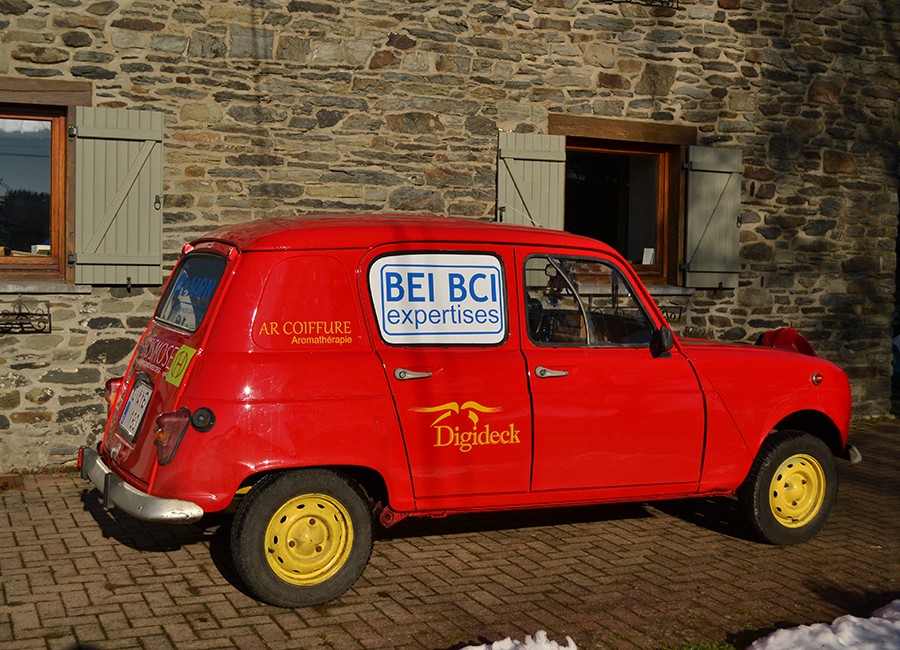 Renault 4L couverte de sponsors dans une allée