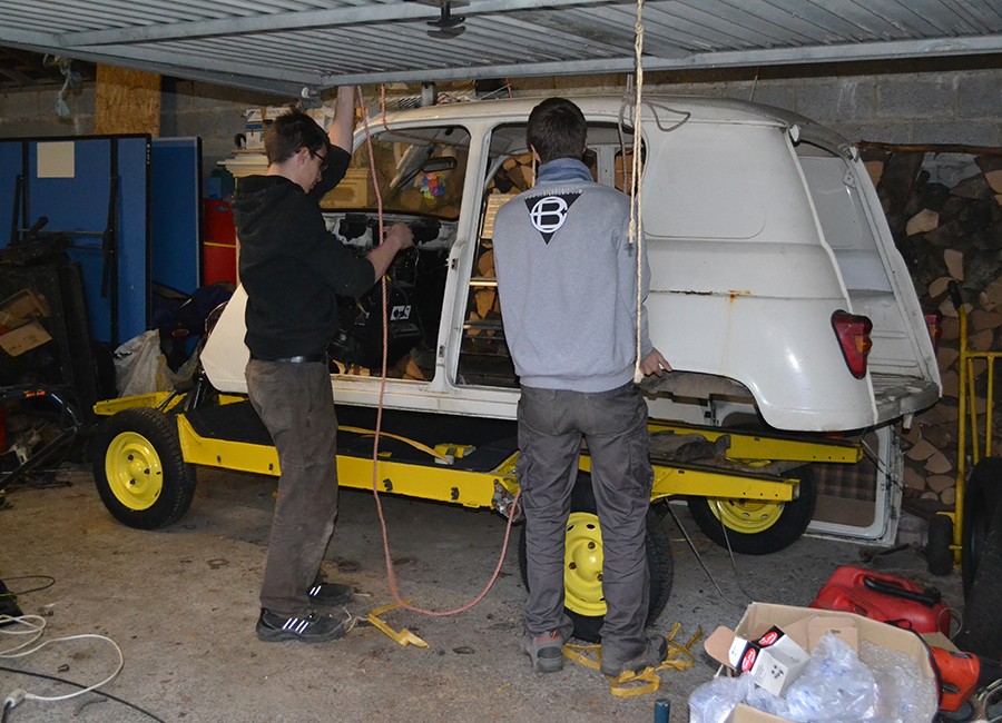 Deux hommes se trouvent devant une Renault 4L en cours d'assemblage