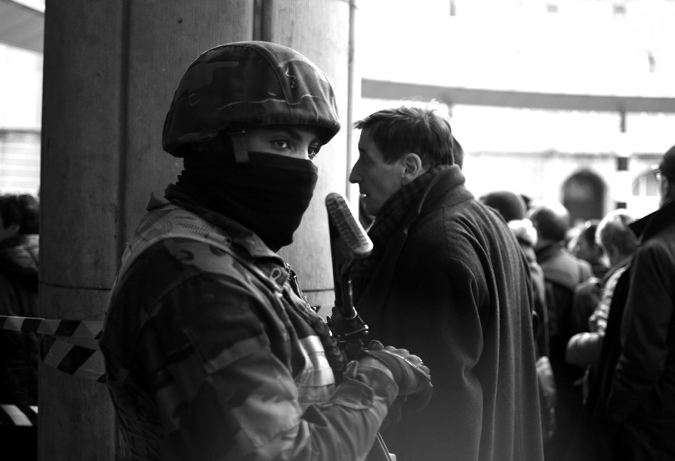 Un militaire est devant la gare de Bruxelles-Central.