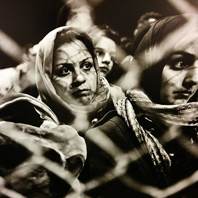 Femmes réfugiées derrière un grillage