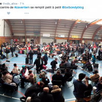 Une foule de personnes est dans la hall des sports à Zaventem.