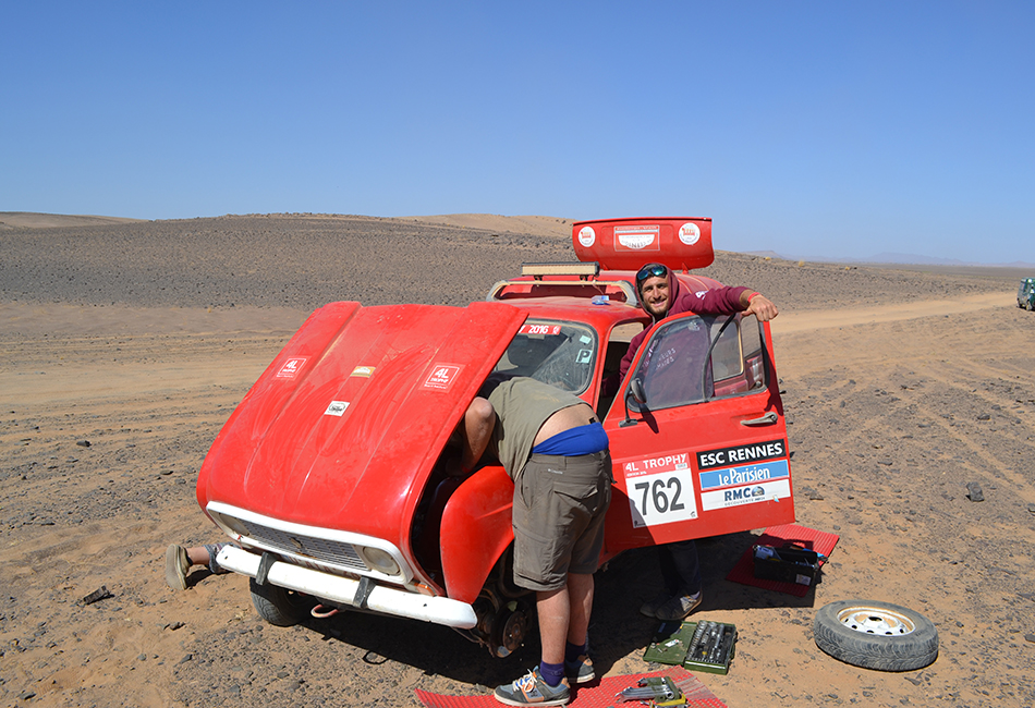 Une voiture à un problème technique sur le parcours: capot ouvert, mais sourires présents