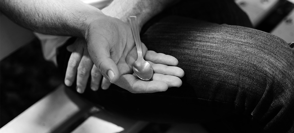 Olivier, ancien détenu, tient une petite cuillère dans la main, symbole de sa détention.