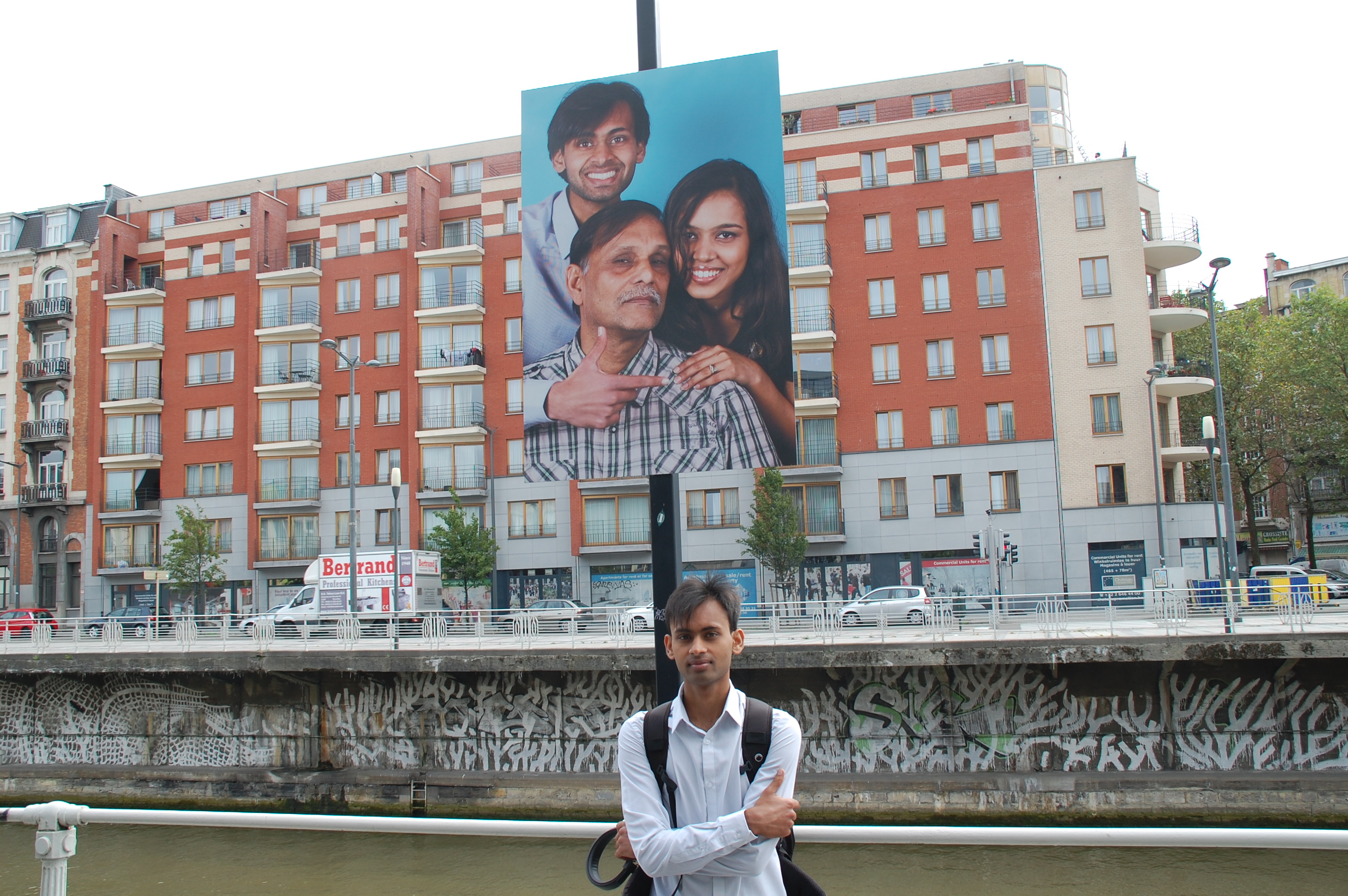 Ahsan pose devant son portrait de famille. 