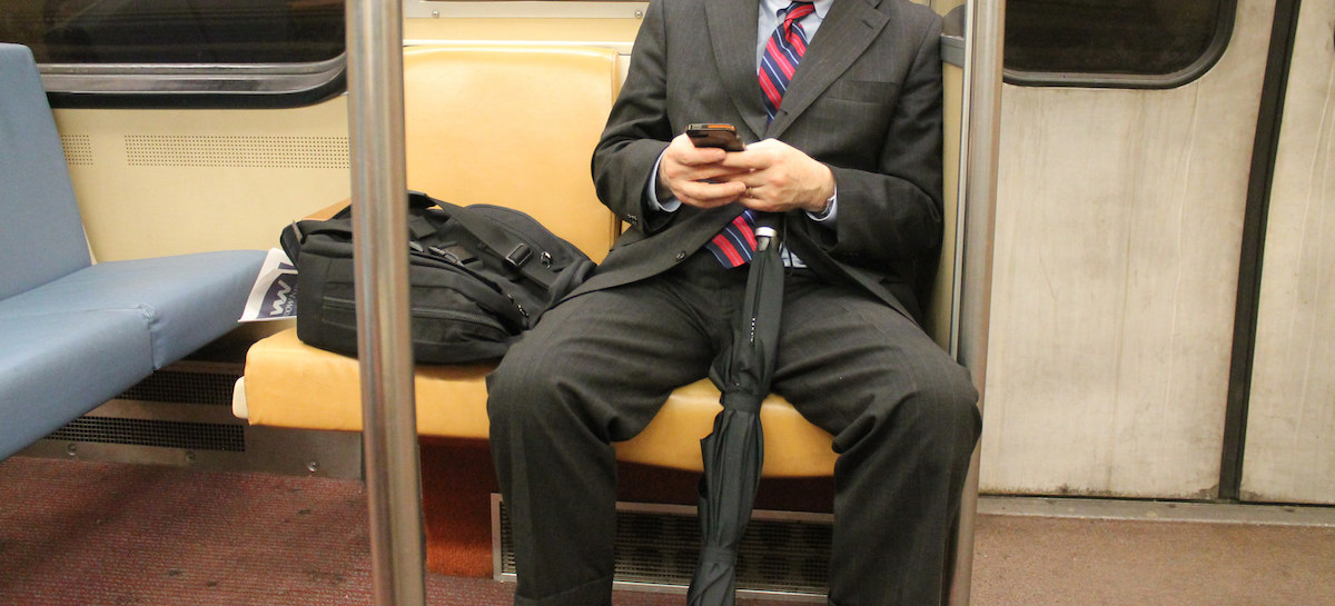 Un homme en costume écarte les jambes, tout en ayant sa veste déposée à côté