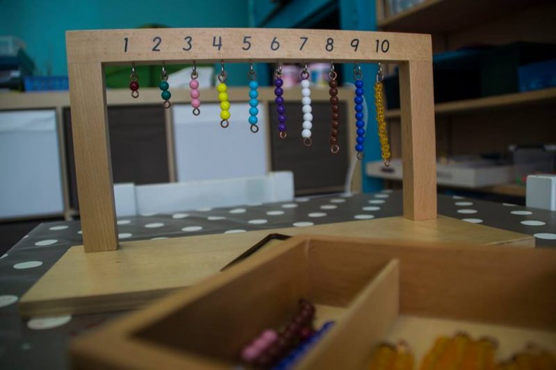 Outils d'apprentissage des mathématiques via des ensembles de perles de couleur représentant un chiffre.
