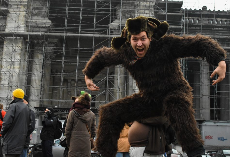 Un militant déguisé en singe saute pour la photo.