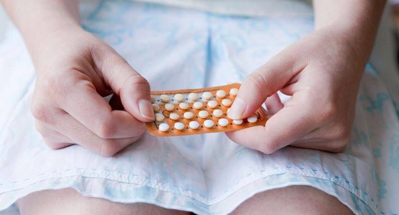 Des mains de femme tiennent une plaquette de pilule contraceptive.