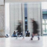 réfugiés assis et passants à la Gare du nord