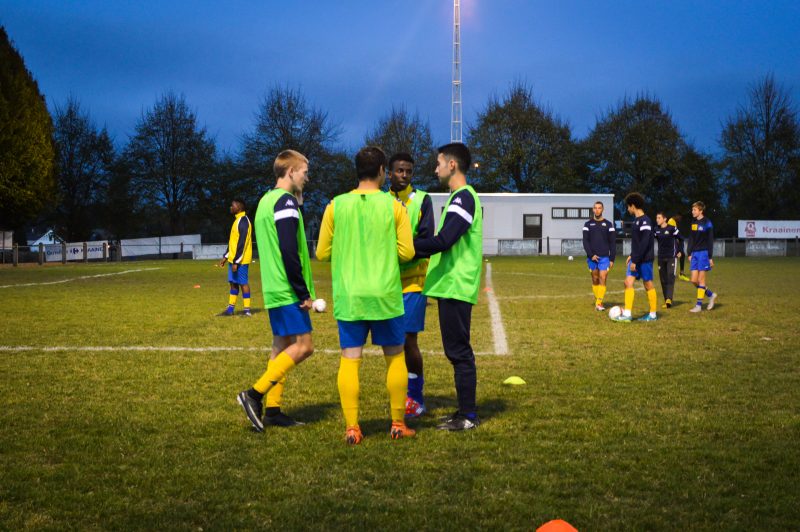 Groupe de quatre joueurs qui discutent à l'entraînement.