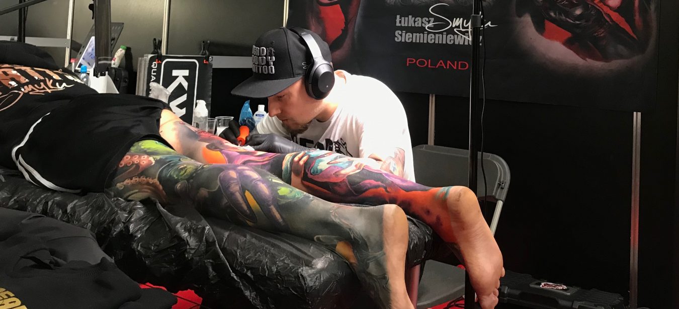 Un artiste tatoueur est en plein travail avec un client.