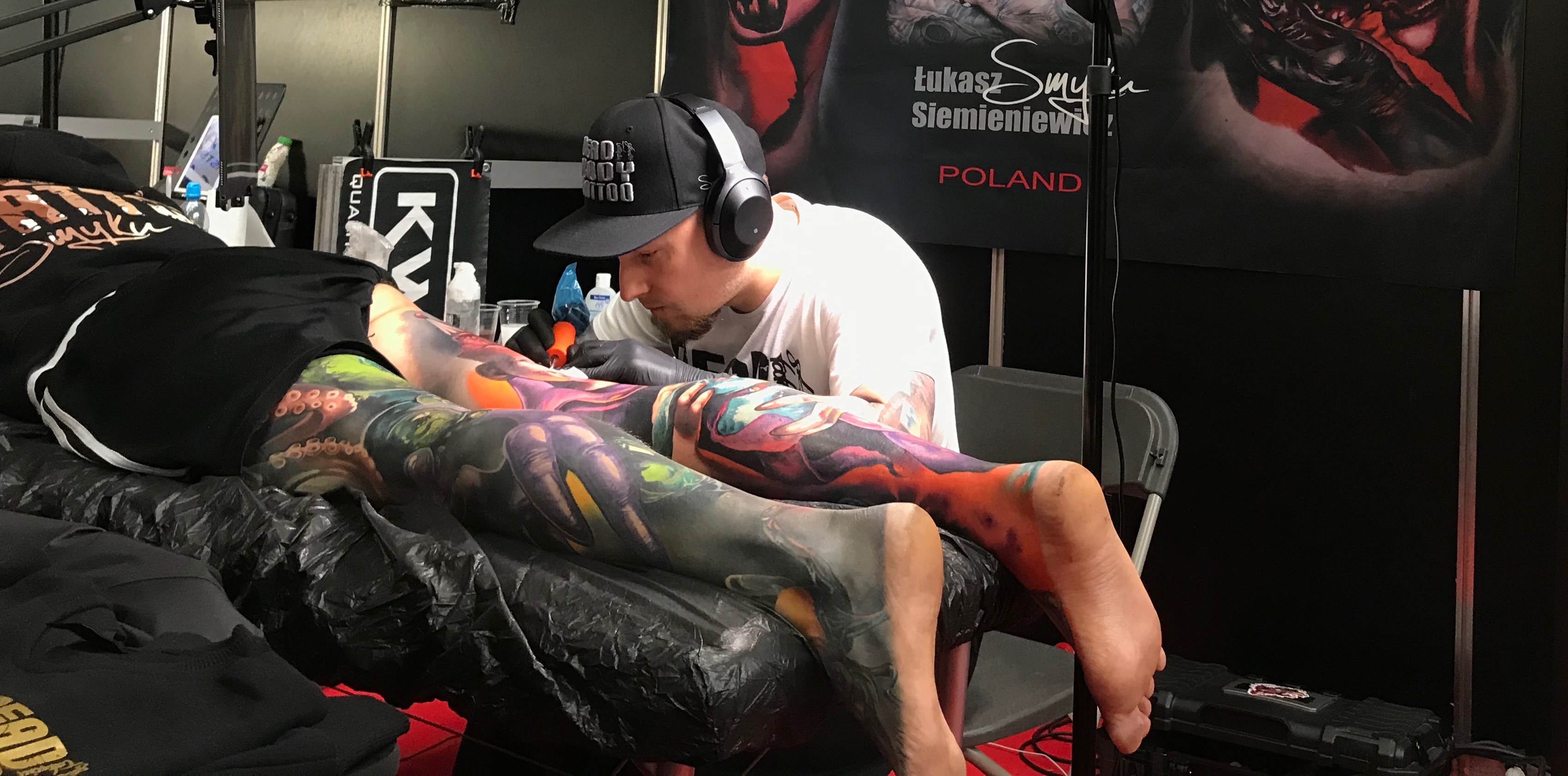 Un artiste tatoueur est en plein travail avec un client.