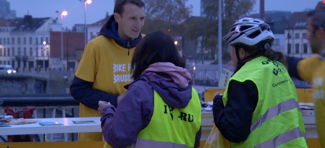 Un bénévole de Bruxelles Mobilité distribue gratuitement des éclairages aux cyclistes en gilet fluo qui n'en ont pas encore.