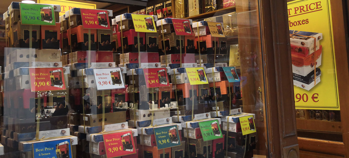 Une vitrine d'un magasin de chocolat propose des assortiments de 6 boites pour 9,90€