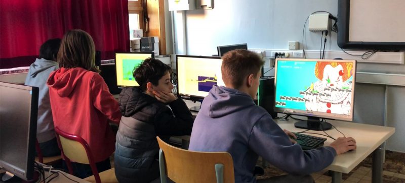 Les enfants testent leurs propres jeux-vidéo sur des ordinateurs et partagent leurs expériences avec les autres participants au stage