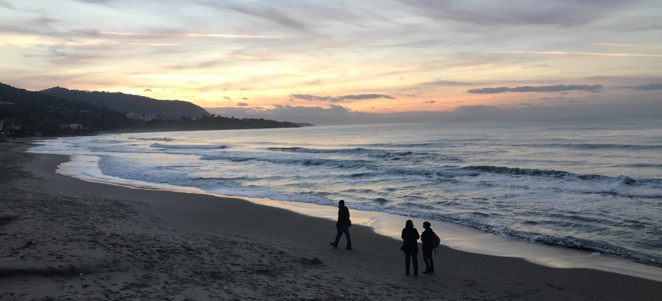 Plage avec coucher de soleil et promeneurs