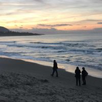 Plage avec coucher de soleil et promeneurs