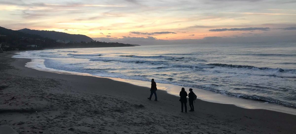 Plage avec coucher de soleil et promeneurs