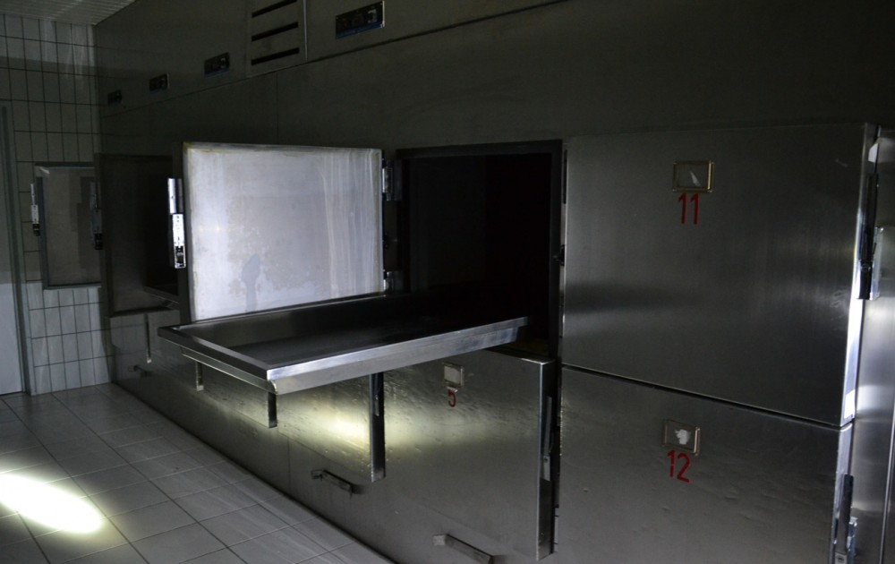 Frigo de morgue ouvert et au tiroir à moitié déployé.