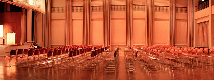 C'est un salle de taille moyenne dont les rangées de chaises rouges sont parfaitement alignées. Le décor tend vers les couleurs rouges, beige et dorée. La scène est pour le coup assez "petite".