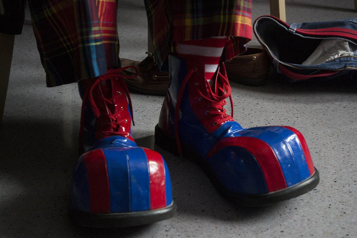 Focus sur une paire de chaussures de clowns rouges et bleues.