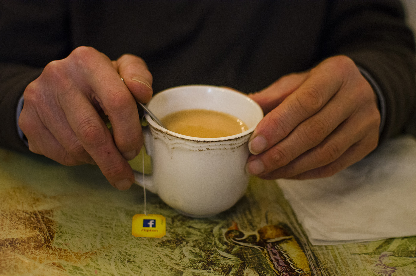 Un homme boit un thé au lait après le repas.