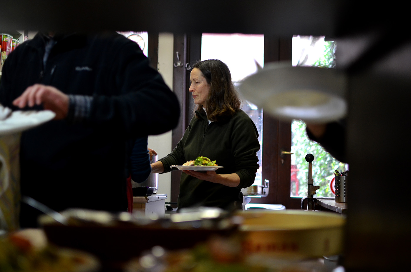 Véronique sert les plats pour le repas de midi.